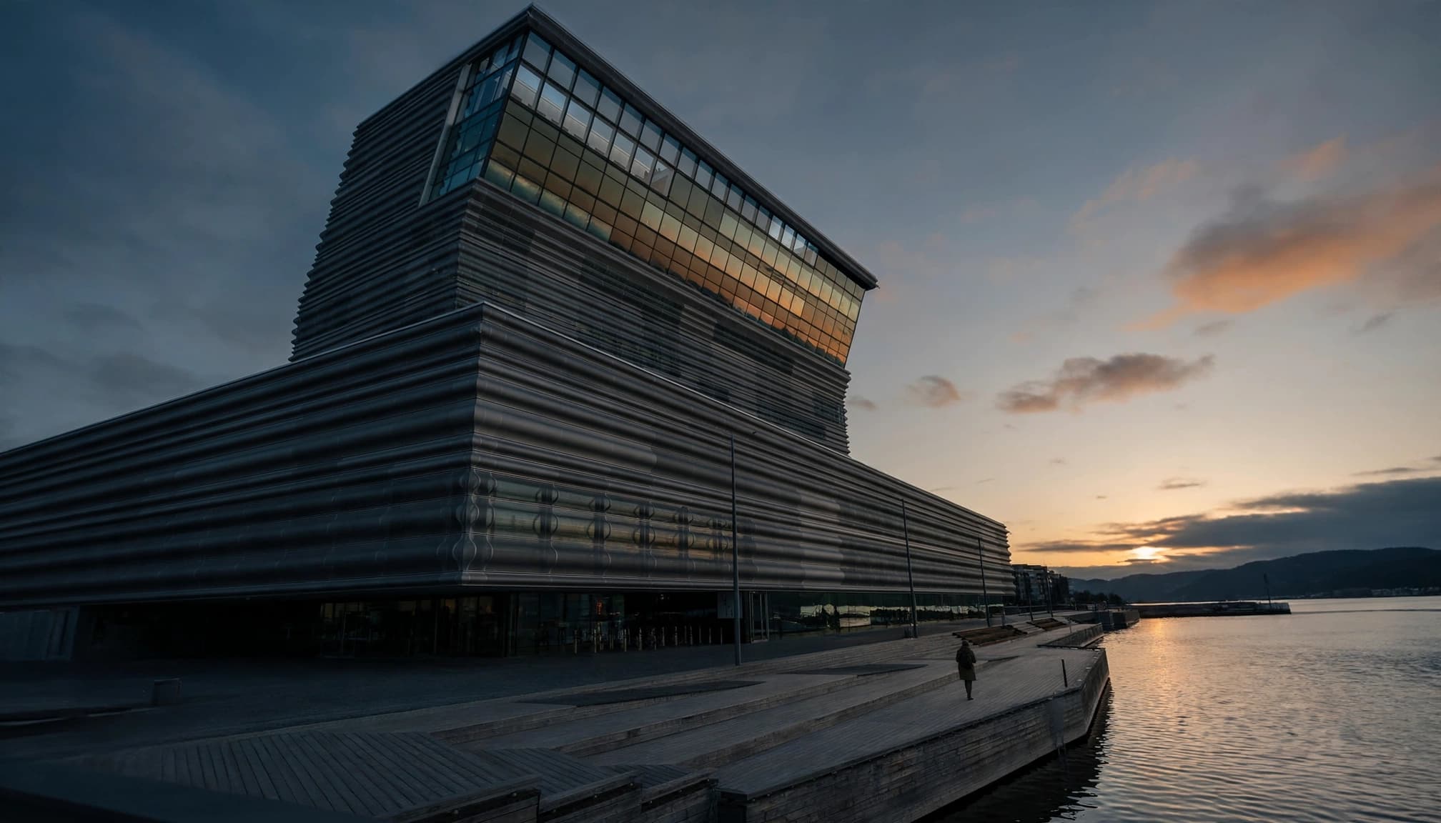 One visitor walks along the waterfront promenade beside Oslo's MUNCH museum.